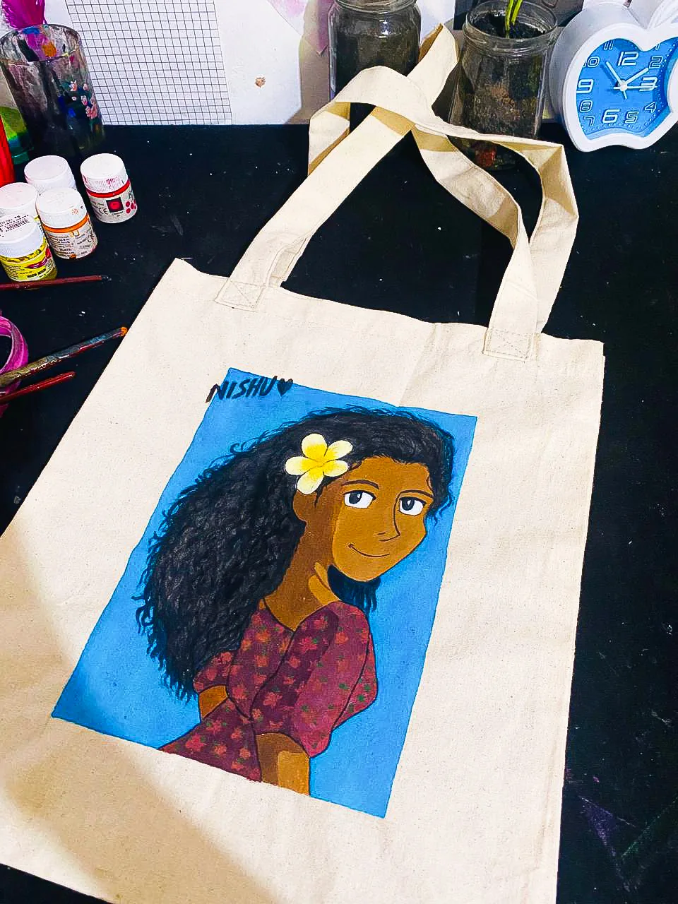 Artist hand-painting a tote bag